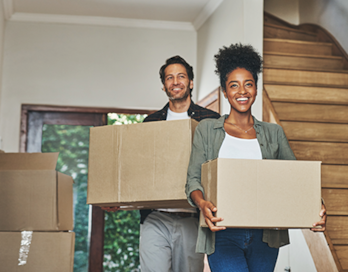 Couple moving boxes into a new home.